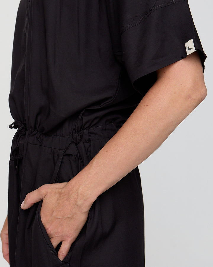 Person wearing a black outfit with a white background