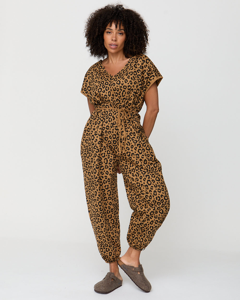 Woman wearing a leopard print jumpsuit on a white background