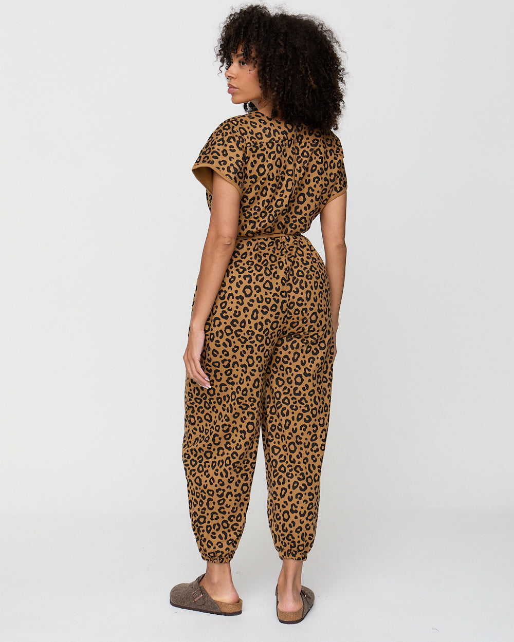 Woman wearing a leopard print jumpsuit on a white background
