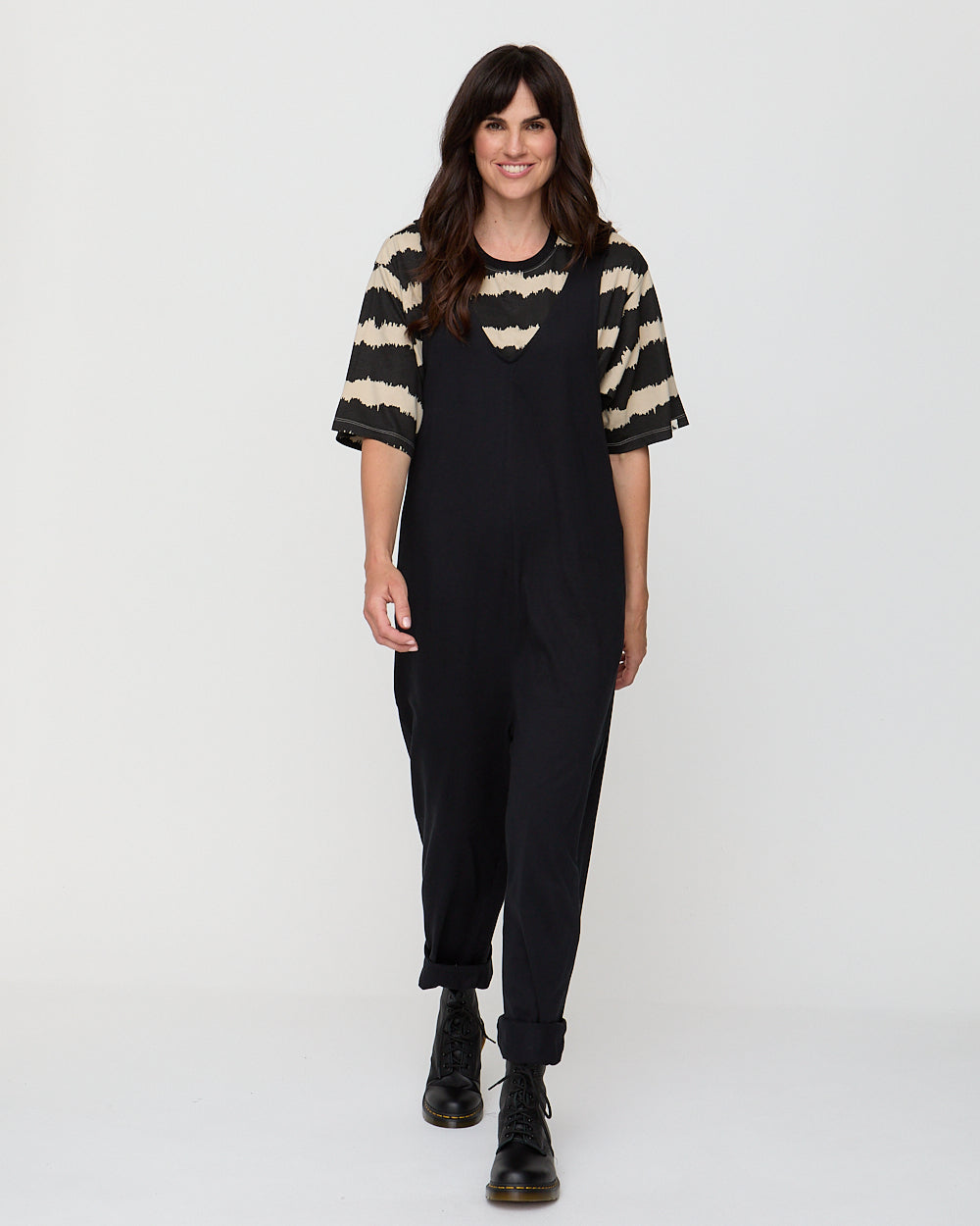Woman wearing a black outfit with a striped sweater on a white background