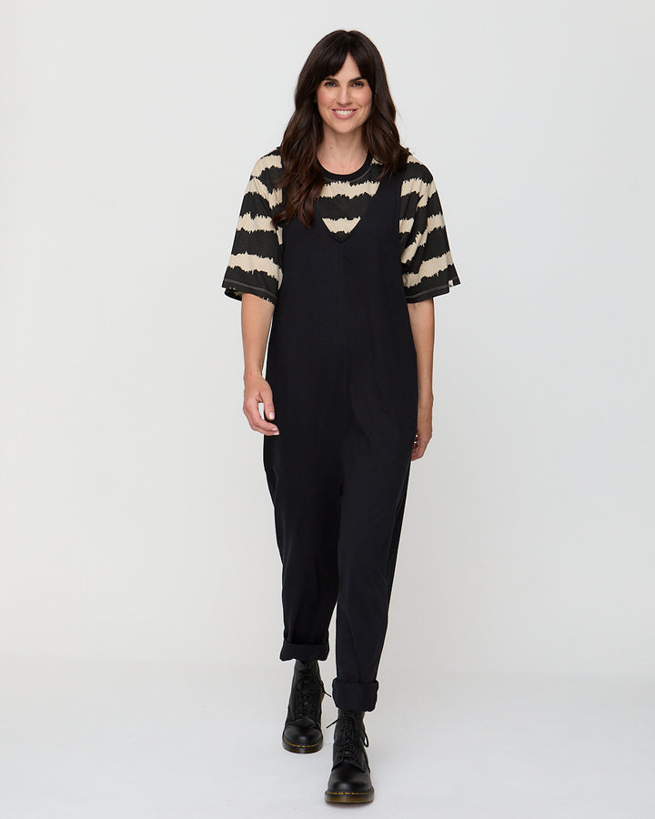 Woman wearing a black outfit with a striped sweater on a white background