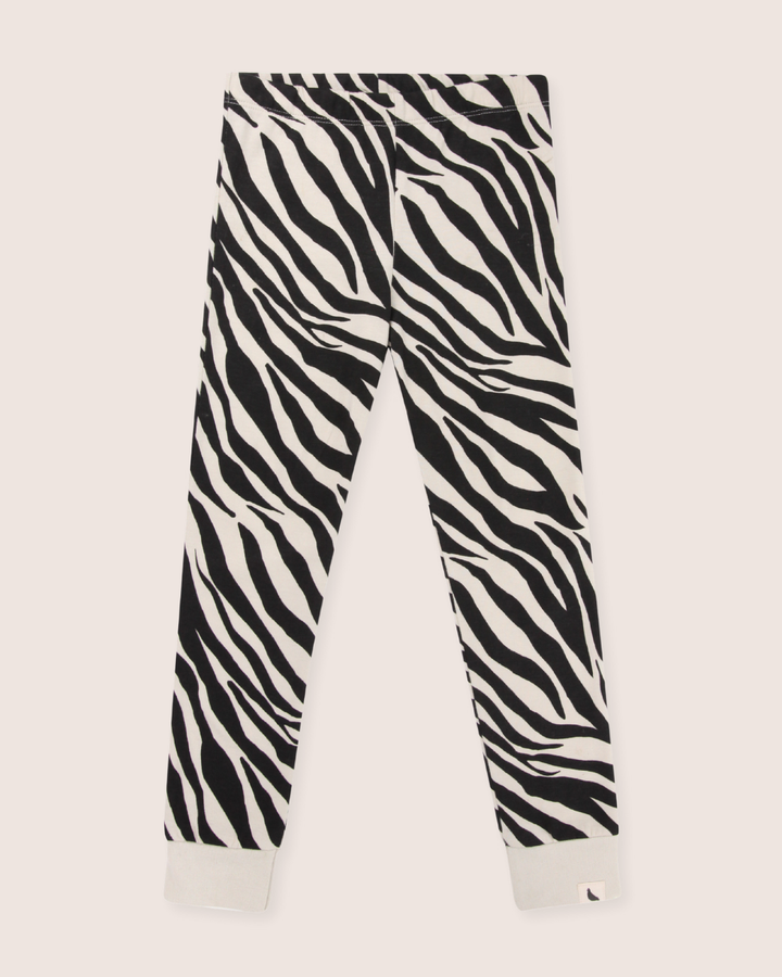 Zebra Skin Leggings in black-and-white zebra print on a light background offer kids sustainable fashion with organic cotton, elastic waistband, and cuffs.