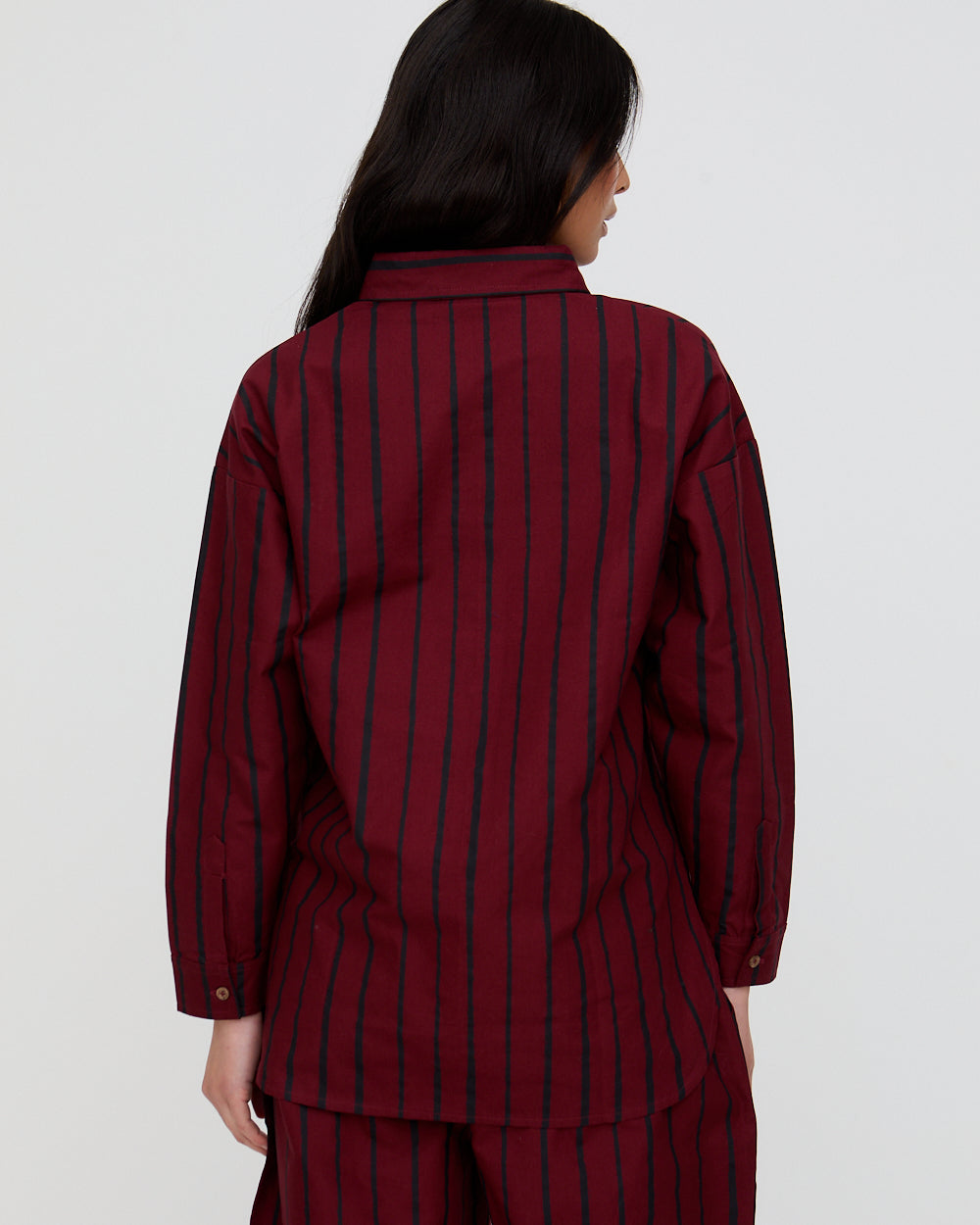 Person wearing a maroon and navy striped outfit on a white background