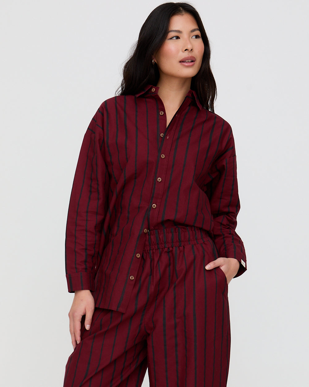 Woman wearing a burgundy striped outfit against a white background