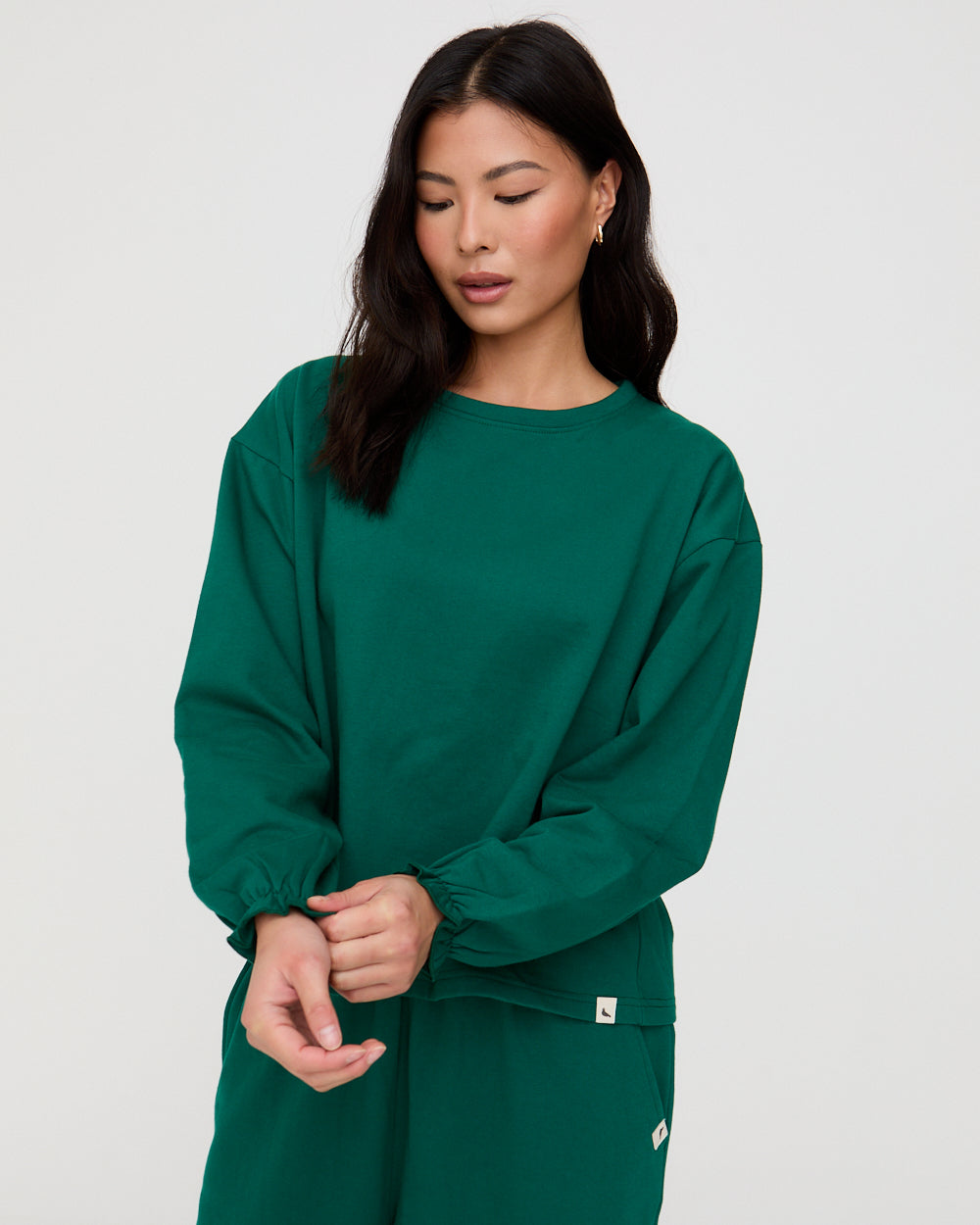 Woman wearing a green outfit against a plain background
