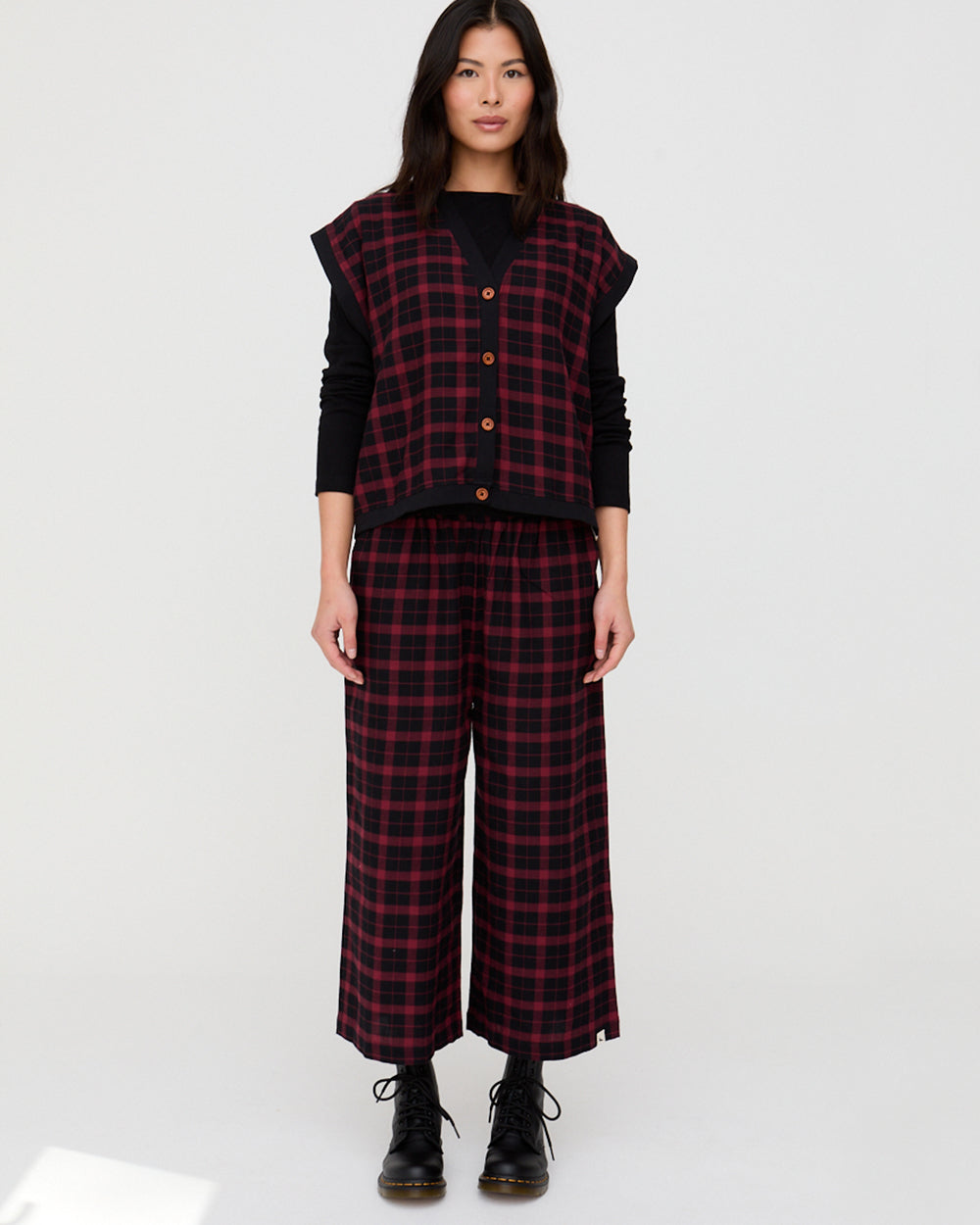 Person wearing a red and black plaid outfit on a white background