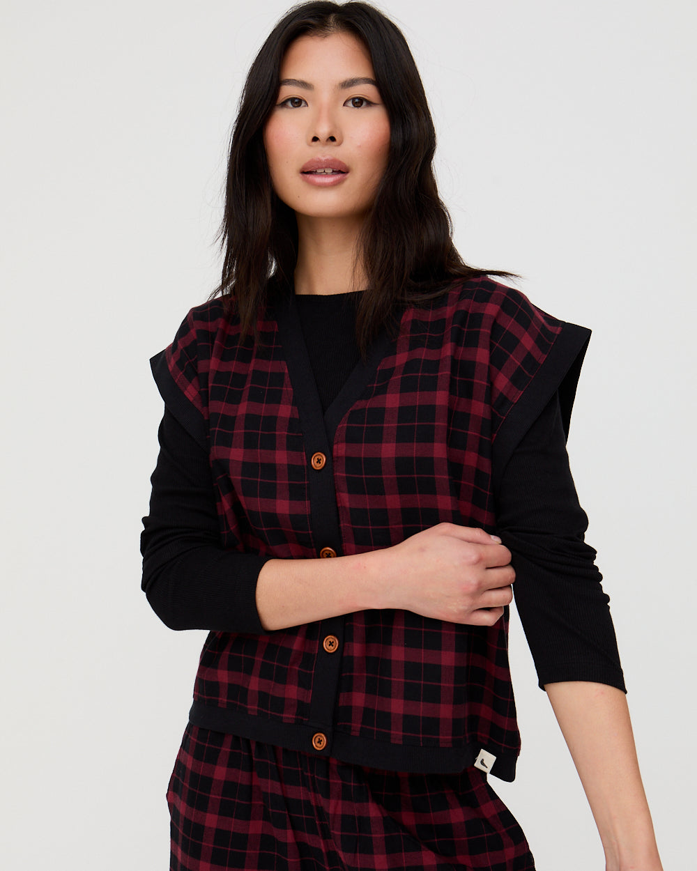 Woman wearing a black and red plaid dress with a plain background