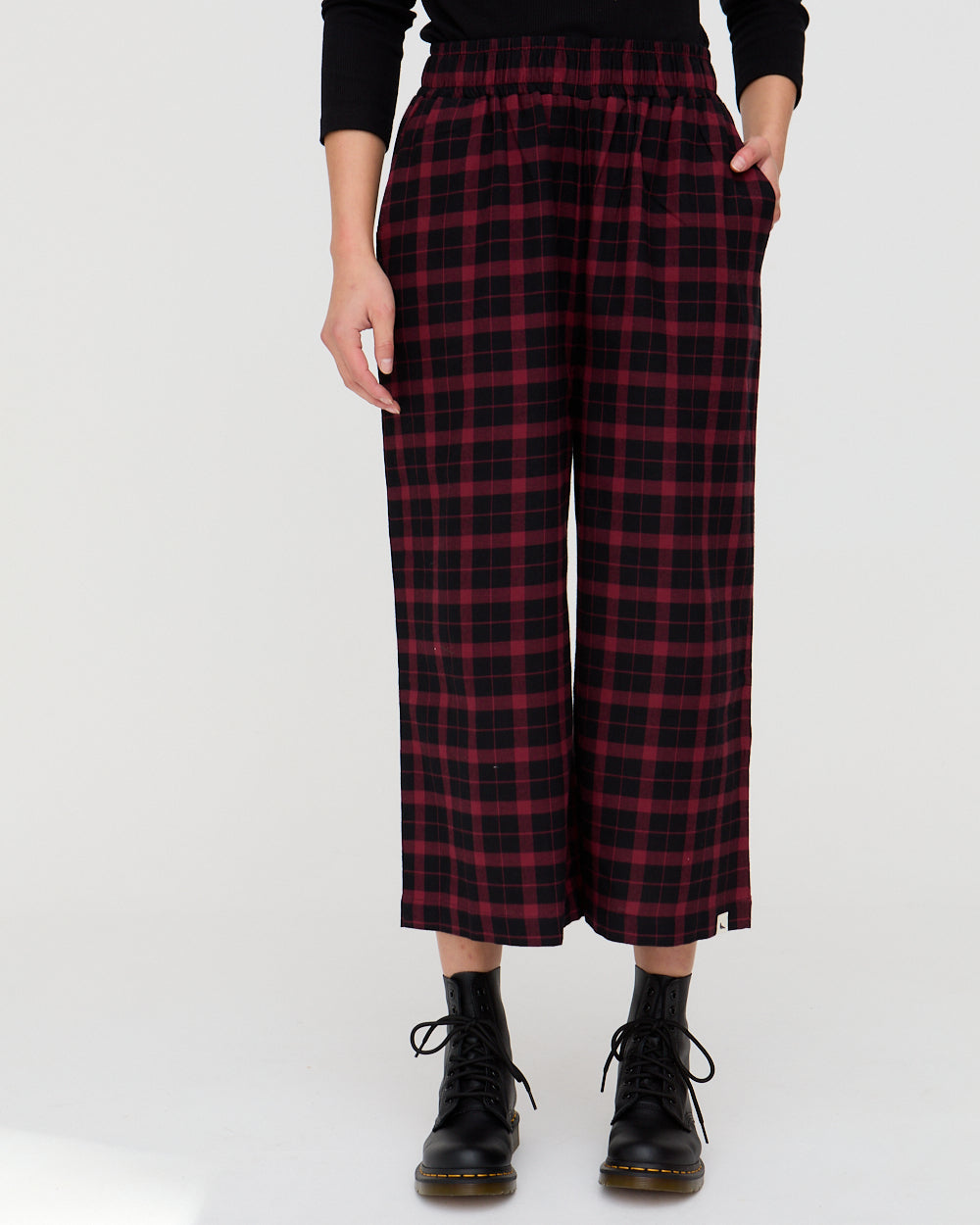 Person wearing red and black plaid pants on a white background