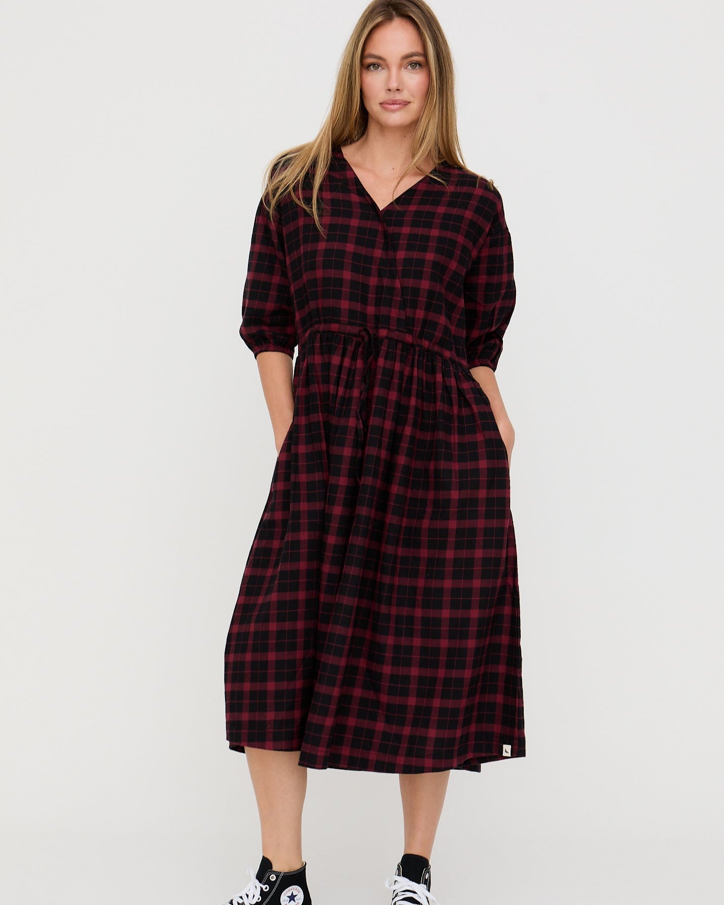 Woman wearing a red and black plaid dress on a white background