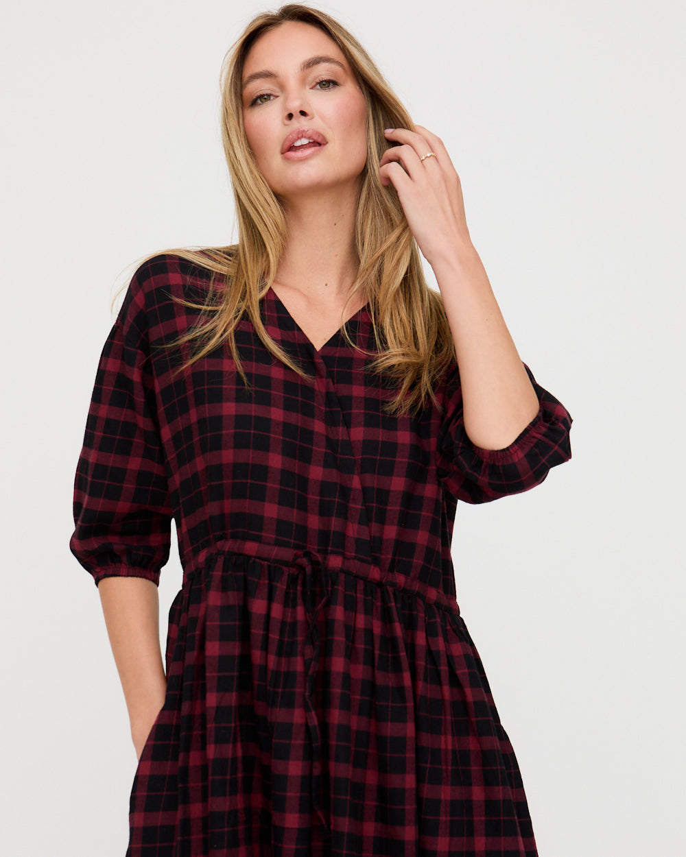 Woman wearing a red and black plaid dress on a white background