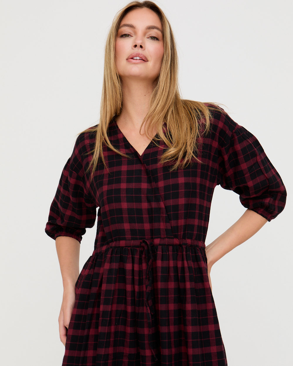 Woman wearing a red and black plaid dress on a white background