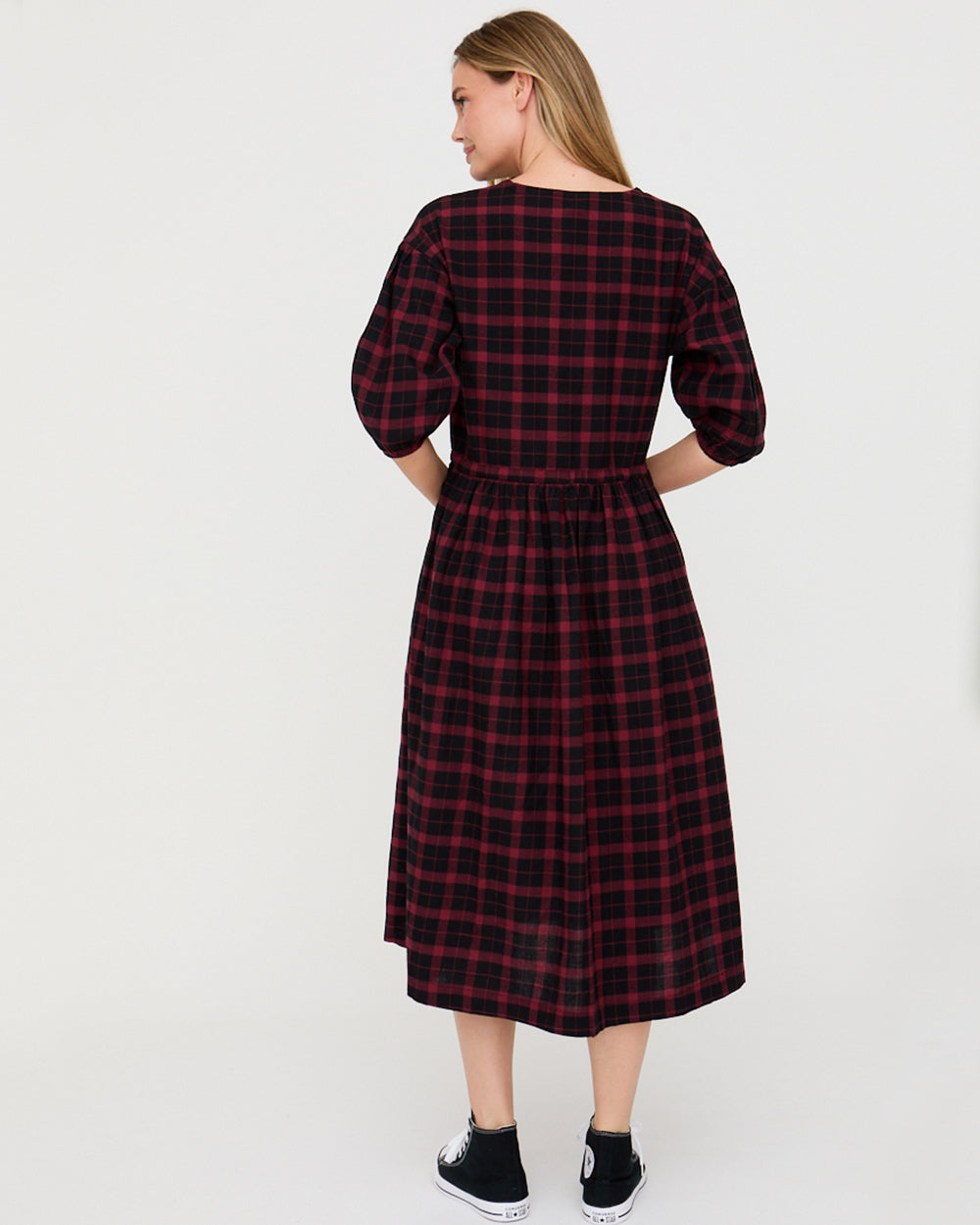 Woman wearing a red and black plaid dress on a white background