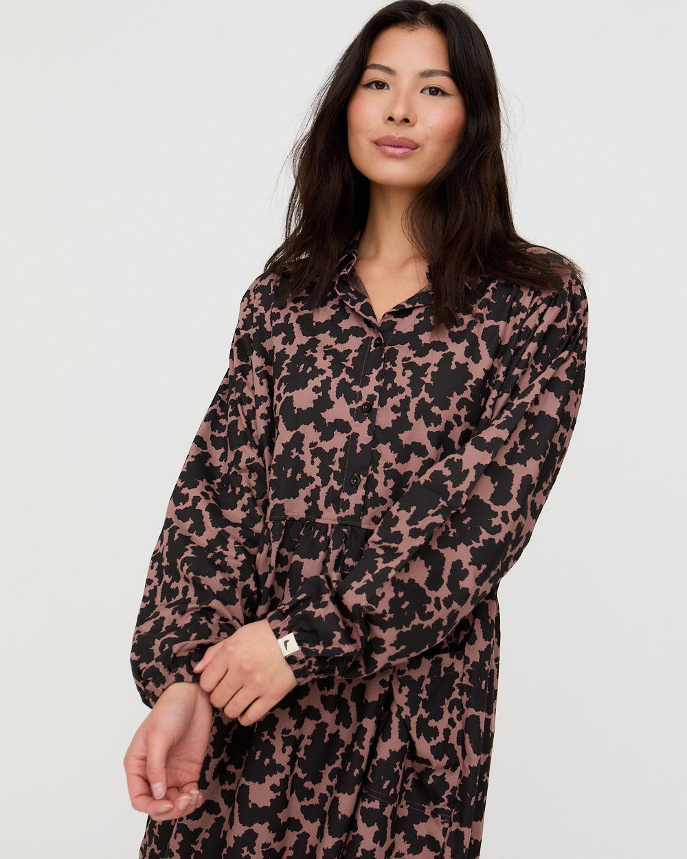Woman wearing a patterned dress against a plain background