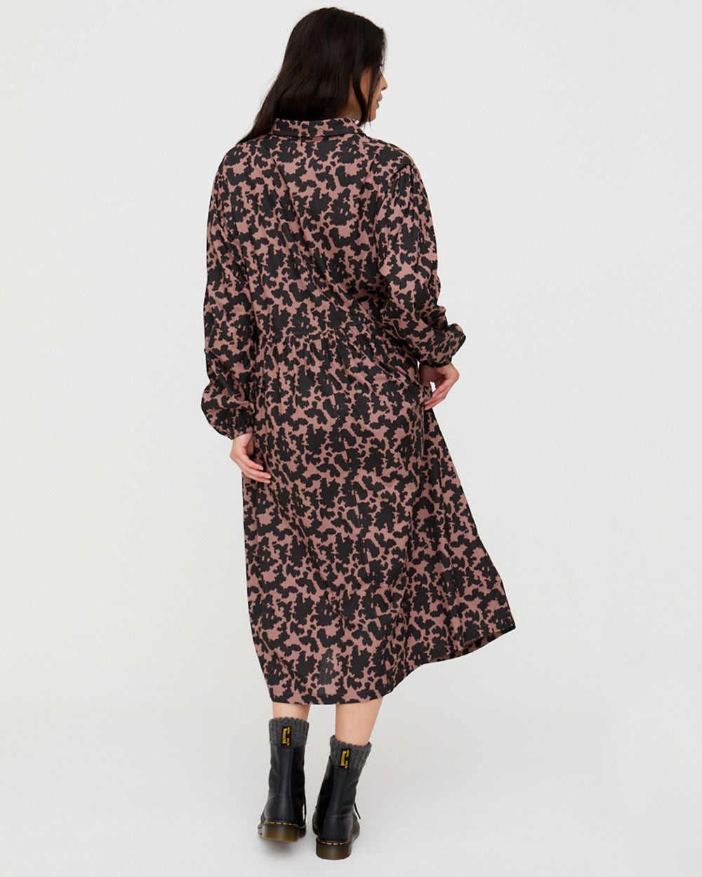 Woman wearing a long floral dress on a white background