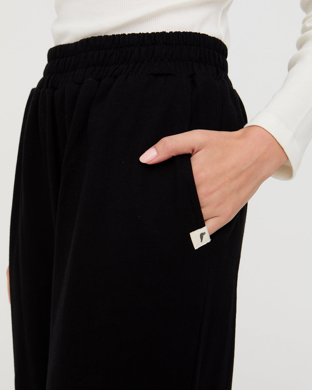 Black pants with a brand logo on a white background