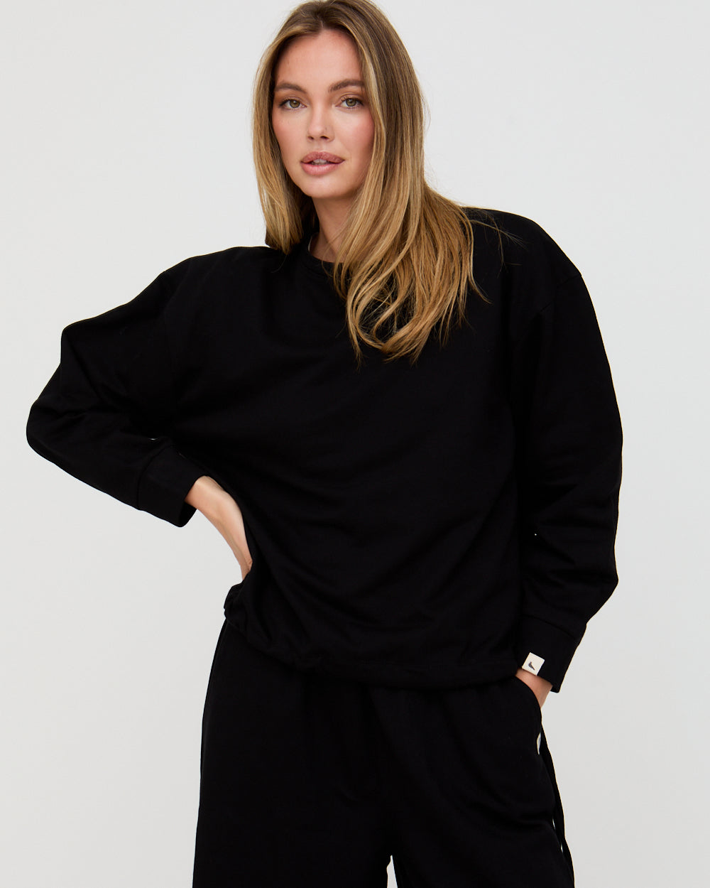 Woman wearing a black outfit against a plain background