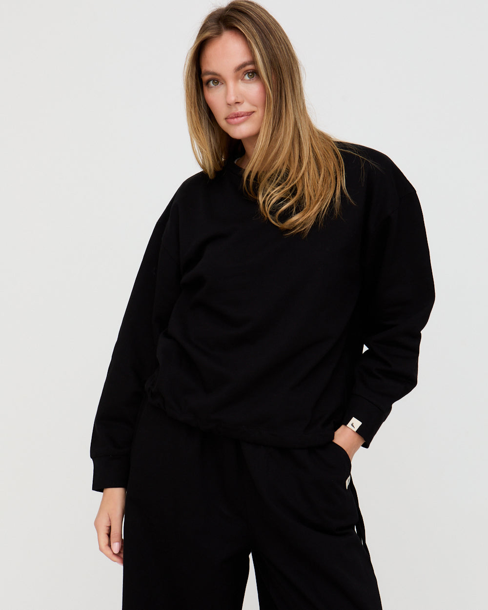 Person wearing a black outfit on a plain background