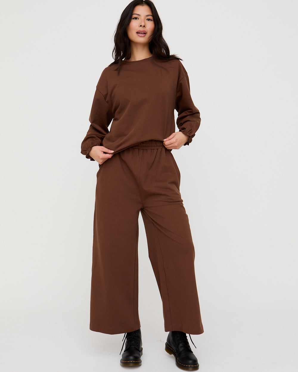 Woman wearing a brown outfit on a white background