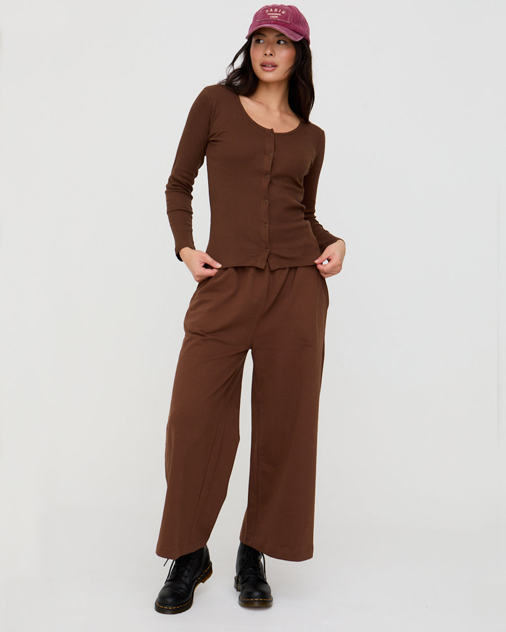 Woman wearing a brown outfit with wide-leg pants on a white background