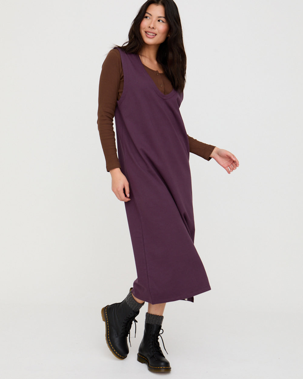 Woman wearing a purple dress with brown sleeves on a white background