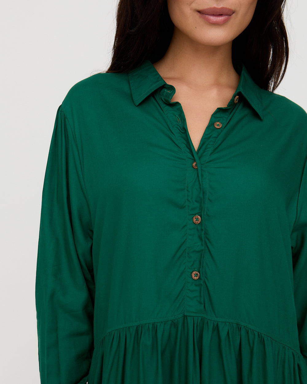 Green shirt worn by a person on a white background