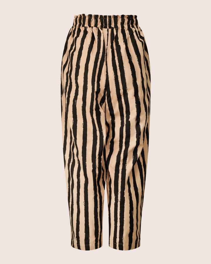 The Kate Painted Stripe Trousers feature wide legs and a high elastic waistband with tan and black vertical zebra stripes. Made from organic cotton, theyre ideal for sustainable wardrobes. Set against a white background, they combine style with eco-consciousness.