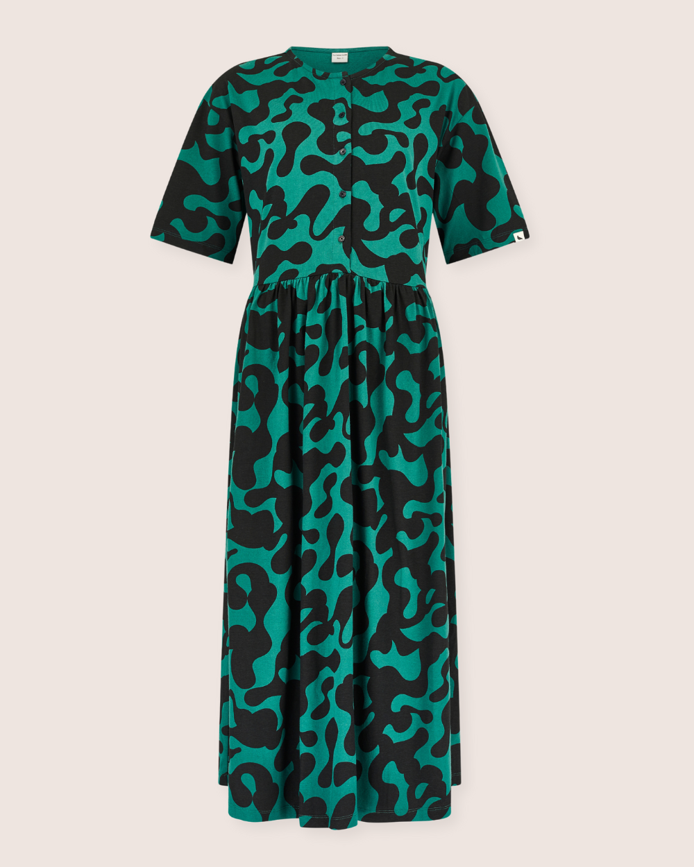 Green and black patterned dress on a beige background