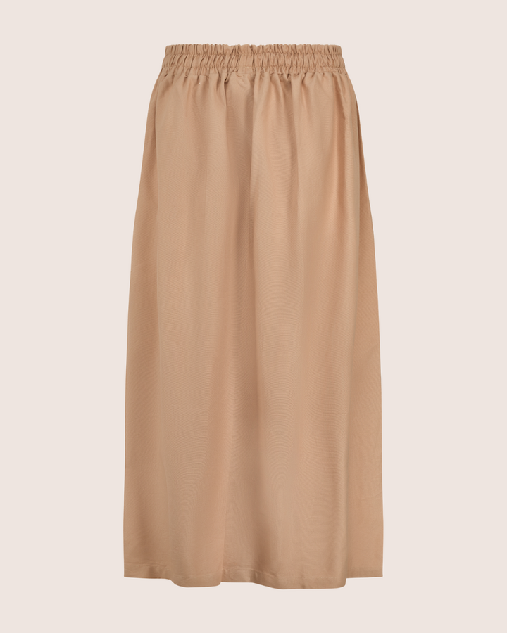 The Joyce Easy Fit Clay Skirt, in beige, features an elasticated waistband. This knee-length piece, displayed on a light background, boasts a lightweight and slightly sheer fabric—ideal for a sustainable wardrobe.