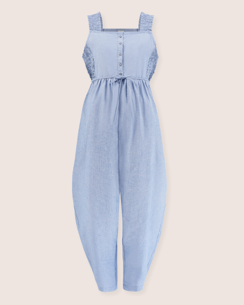 The Alice Chambray Dungarees are light blue sleeveless jumpsuits made from organic chambray, featuring a fitted shirred bodice and button-up front for breastfeeding ease. They include wide straps, tapered pants, and a cinched waist for a relaxed fit.