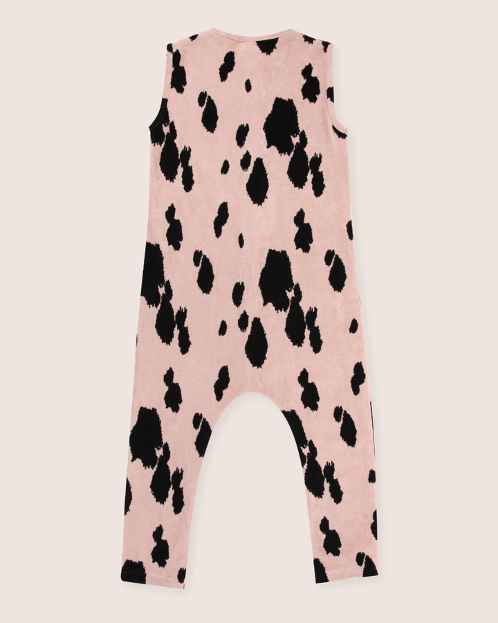 The Pony Velour Dungarees are sleeveless, organic velour rompers featuring black cow-print spots on a pink backdrop. Designed with legs extending to the ankles, theyre perfect for sustainable wardrobes, seamlessly blending comfort and style.