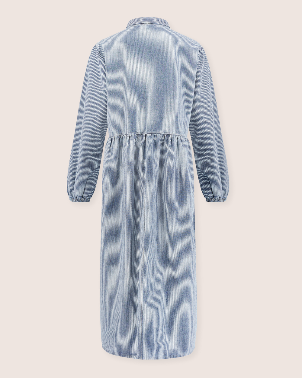 Back view of the Magda Pinstripe Denim Dress, a long-sleeved light blue corduroy dress made from organic cotton denim. It features a high waistline, gathered skirt, relaxed fit, and a plain background.