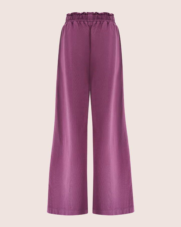 Noor Wide Leg Plum Trousers made from organic cotton, featuring an elastic waistband and subtle sheen. Displayed against a plain background, shown from the back view.