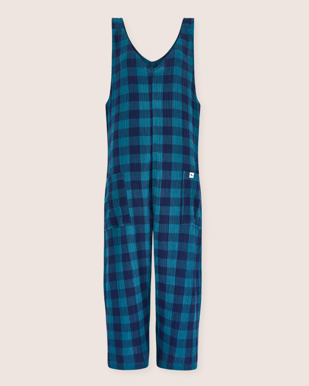 Meet the Grace Check & Stripe Reversible Navy Jumpsuit: a blue and green plaid sleeveless jumpsuit with a V-neckline. Made from organic cotton, it features textured fabric and two pockets on each side, ideal for your sustainable wardrobe against a light background.