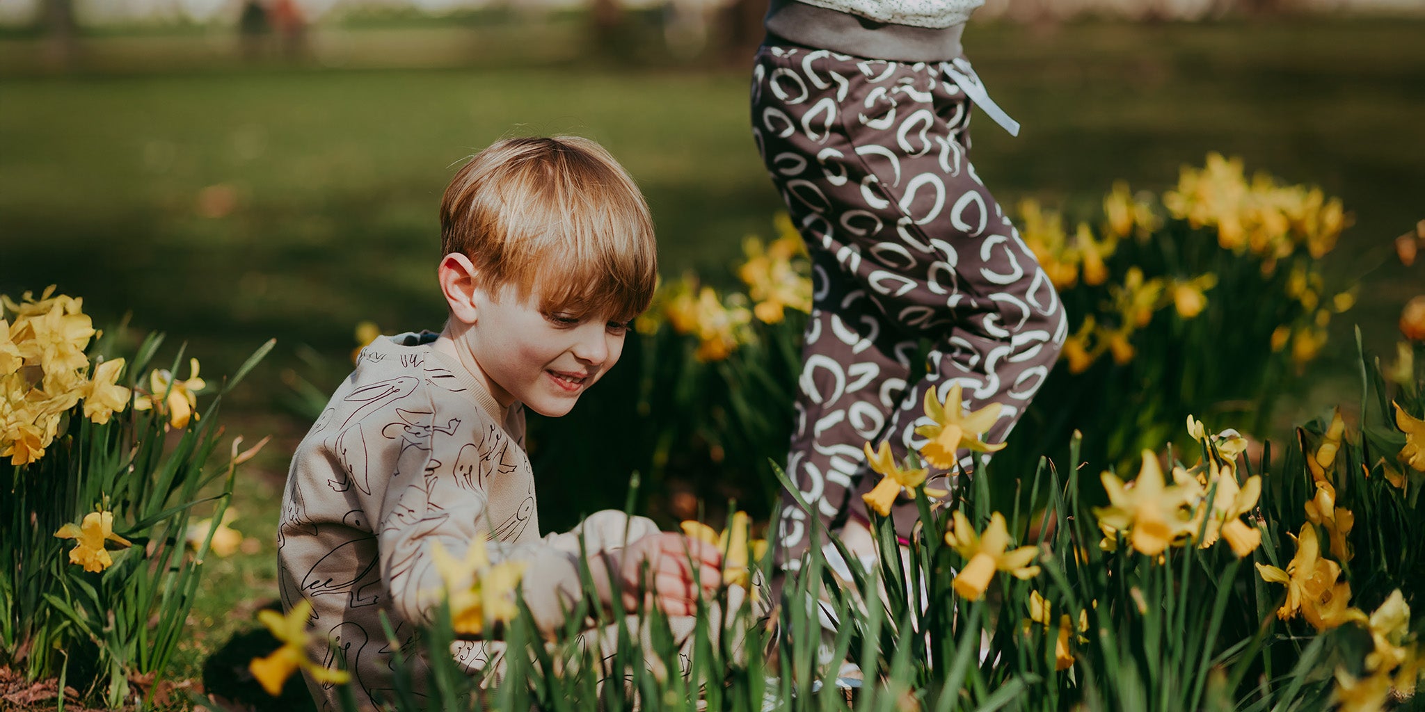 Child playing in a field of yellow flowers