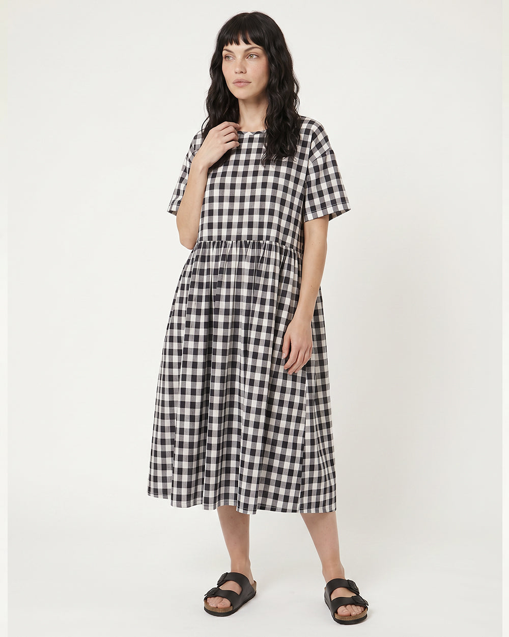 Woman wearing a black and white checkered dress on a white background