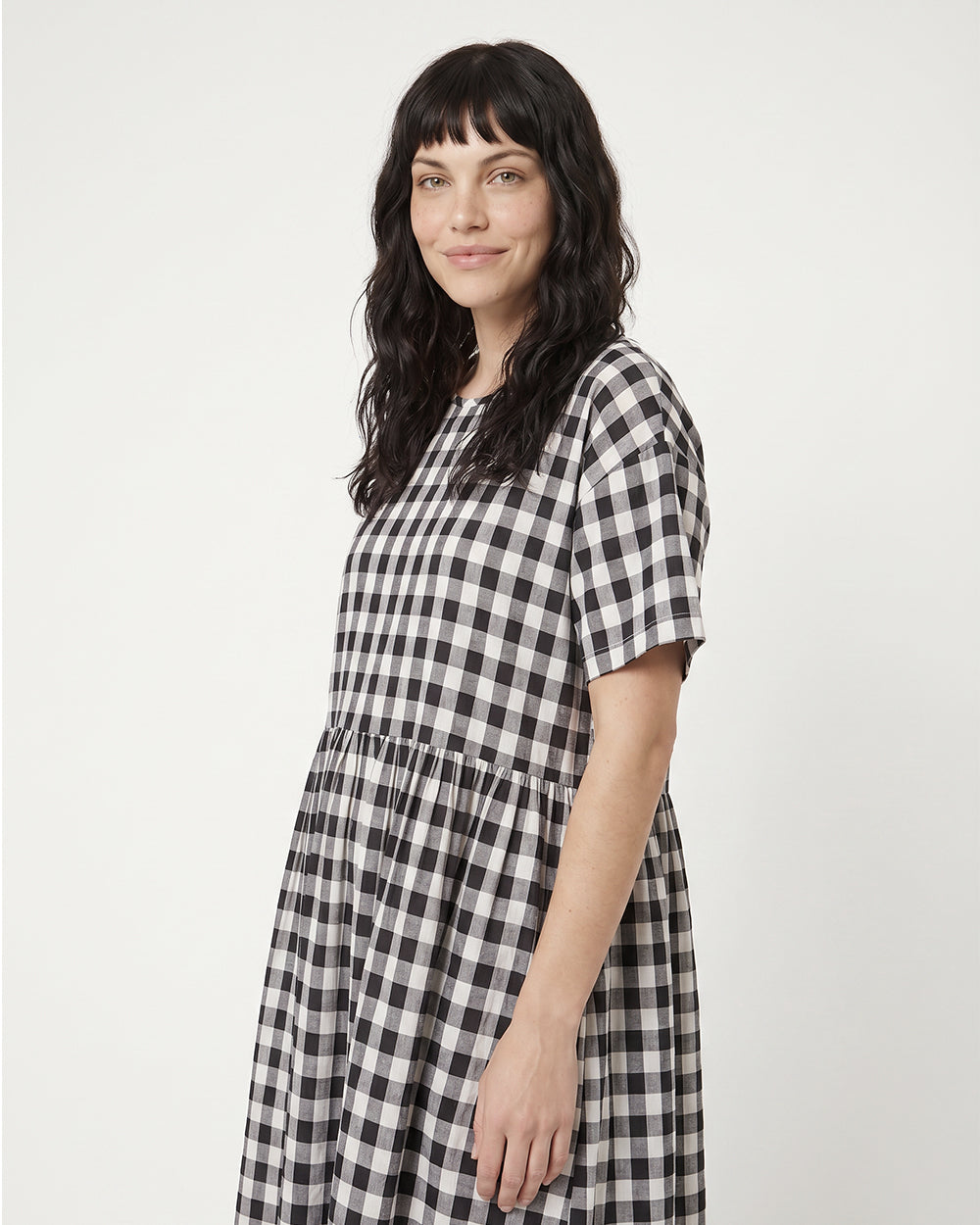 Woman wearing a black and white checkered dress on a white background