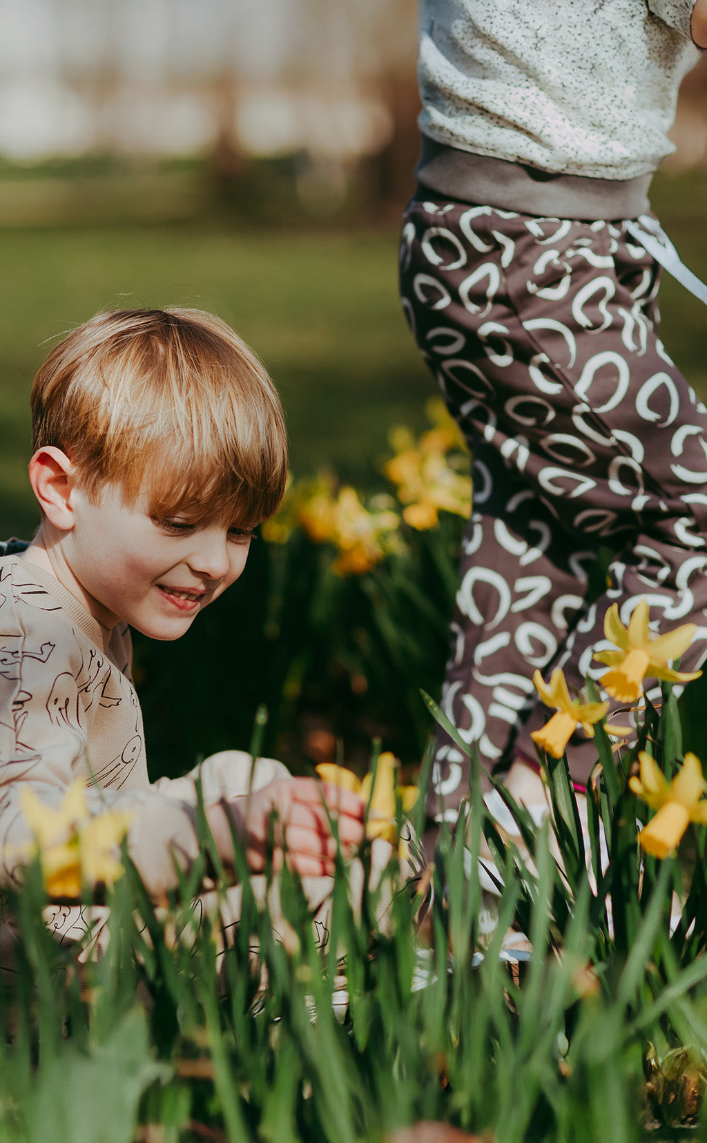 Child playing with daffodils in a garden