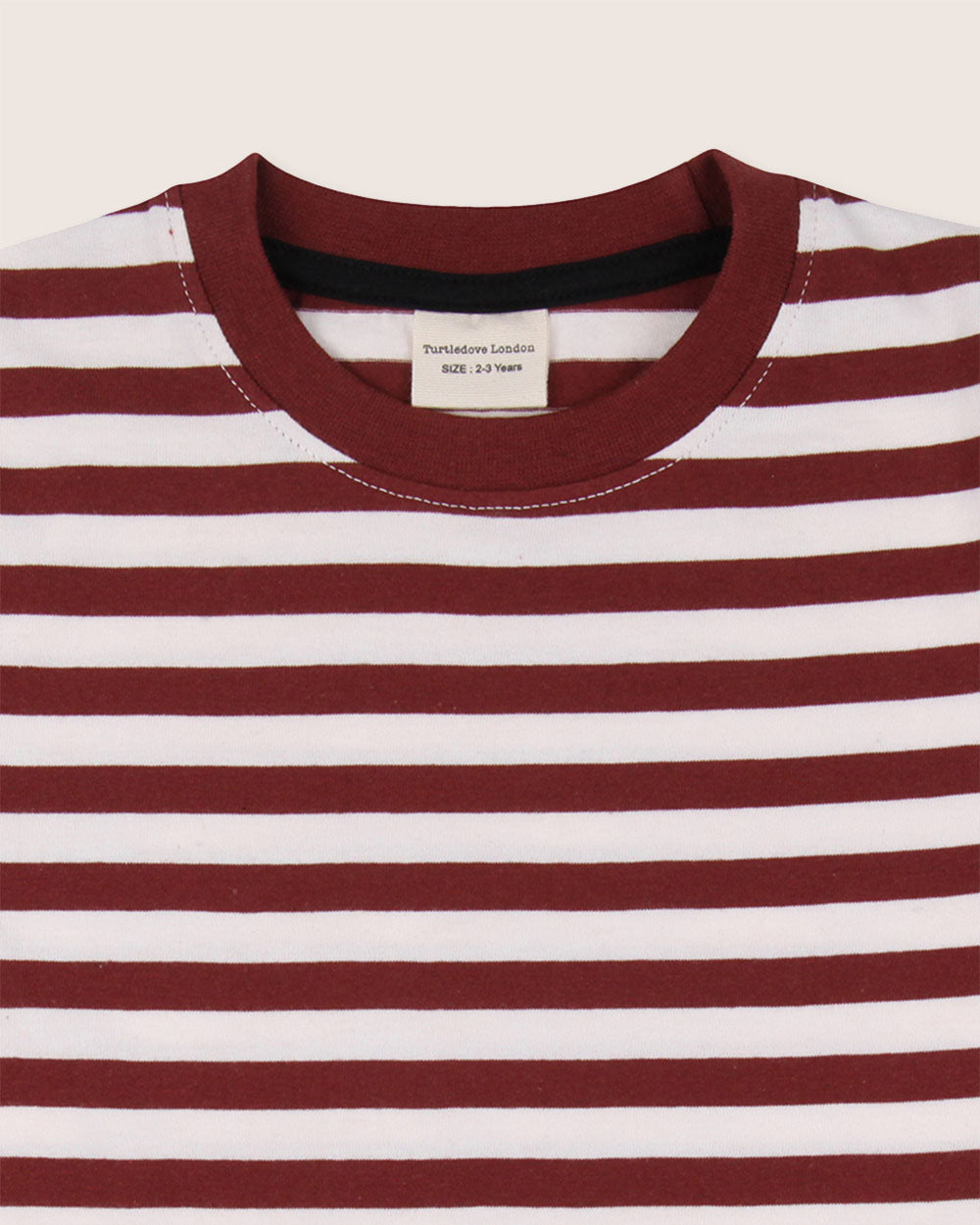 A close-up of the Pond & Stripe Layering T-Shirt shows a red and white striped organic cotton top with a ribbed maroon collar. The inside label states its for ages 2-3 years, making it a sustainable essential for kids wardrobes.
