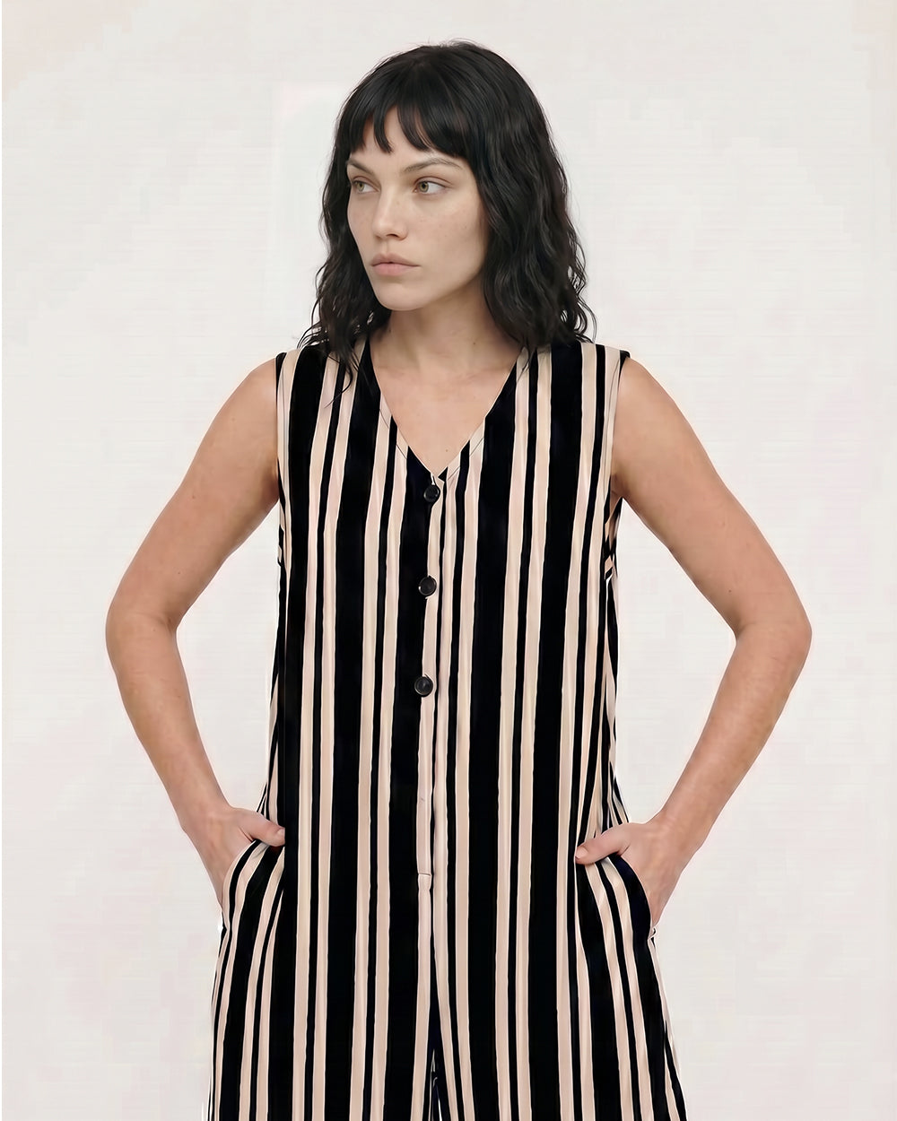 Woman wearing a black and beige striped dress against a white background