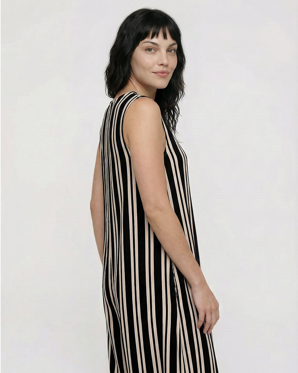 Woman wearing a black and beige striped dress on a white background