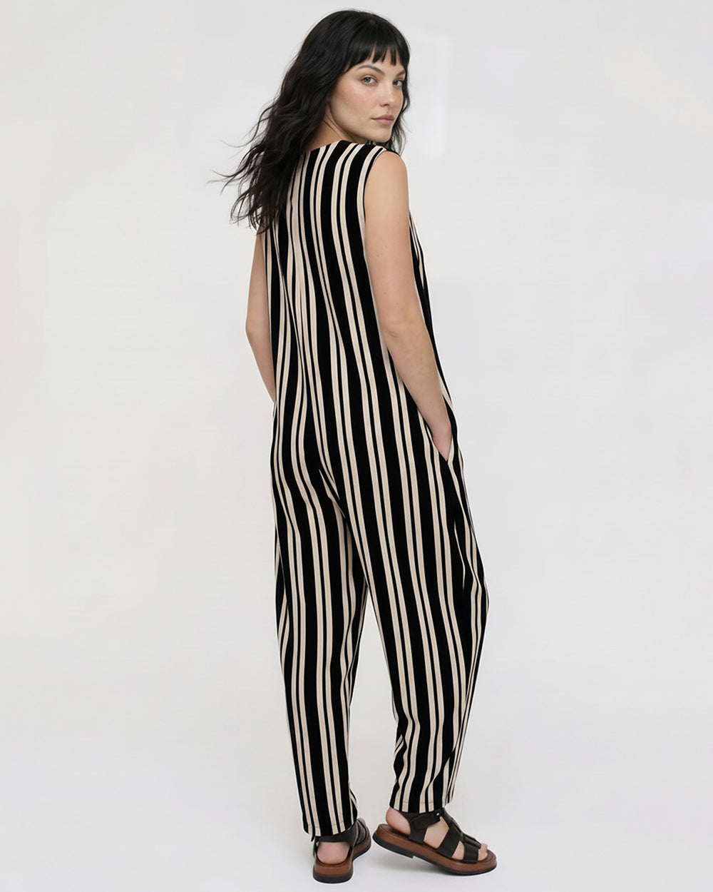 Woman wearing a black and white striped jumpsuit on a white background