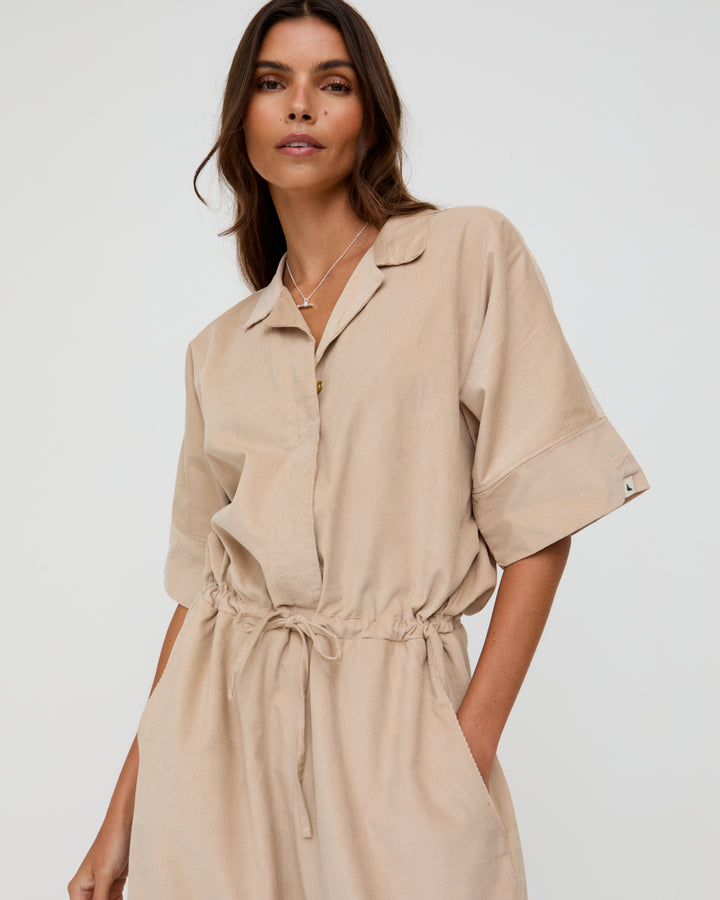 Woman wearing a beige dress against a white background