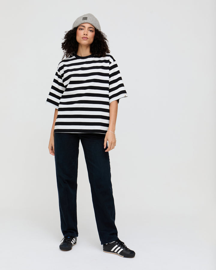Person wearing a black and white striped shirt with a plain background