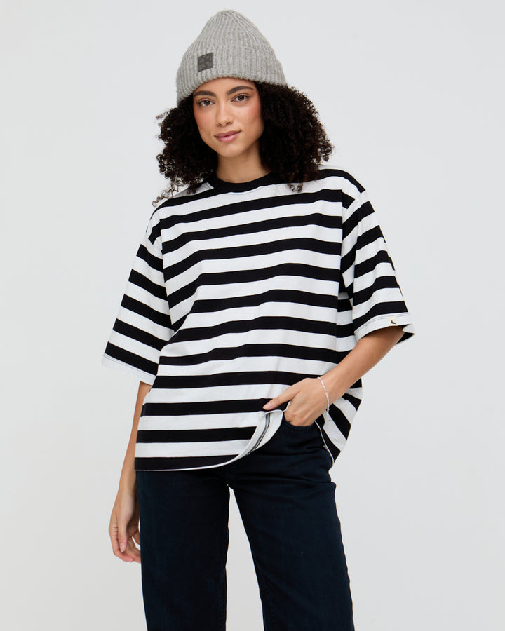 Person wearing a black and white striped shirt with a plain background