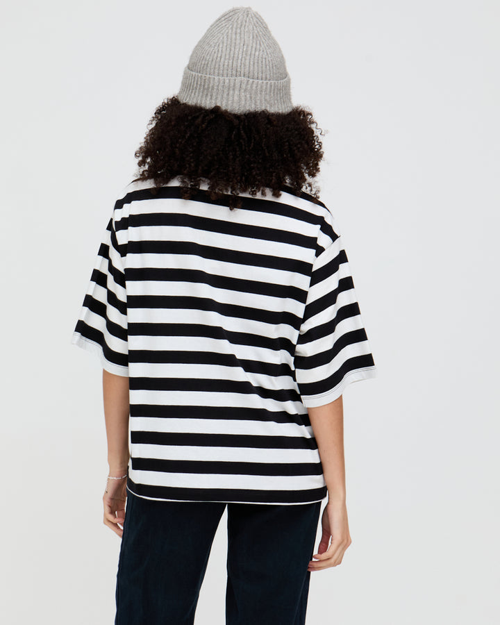 Person wearing a black and white striped shirt with a plain background