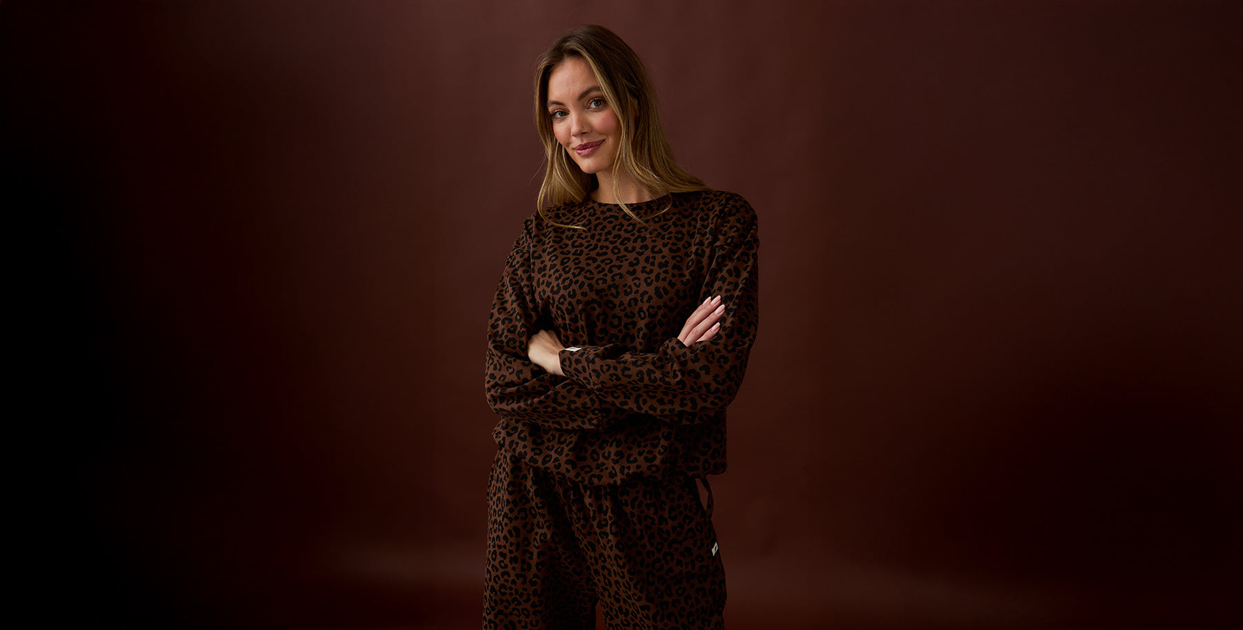 Woman wearing a leopard print outfit against a brown background