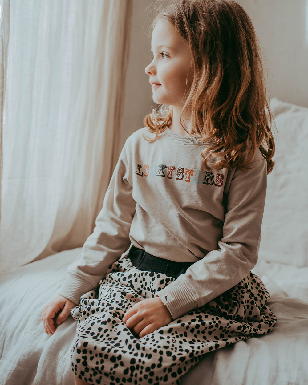 Girl wearing unisex organic cotton kids long-sleeve sweatshirt