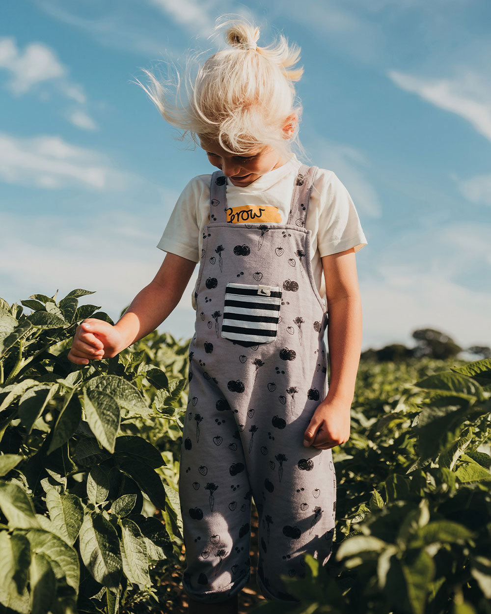 Boy wearing gender-neutral organic cotton short kids dungarees